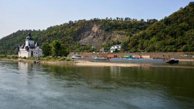 Ein Containerschiff mit reduzierter Ladung passiert die auf einer Felseninsel im Rhein errichtete Zollburg Pfalzgrafenstein. 