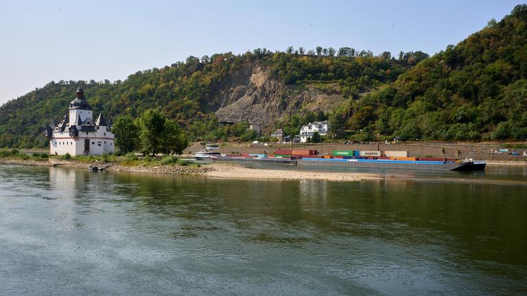 Ein Containerschiff mit reduzierter Ladung passiert die auf einer Felseninsel im Rhein errichtete Zollburg Pfalzgrafenstein. 