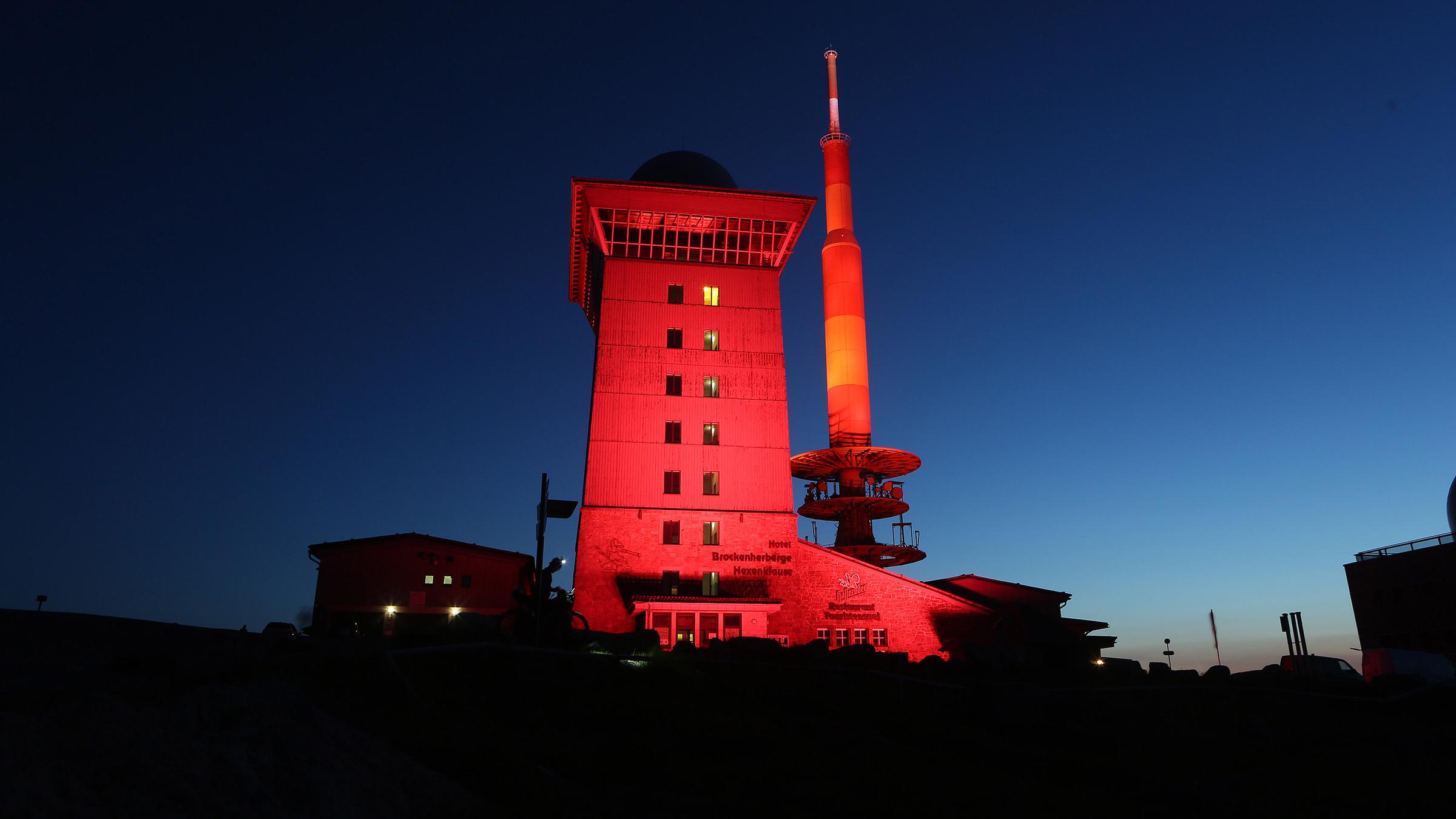 Das Brockenhotel auf der höchsten Erhebung des Harz leuchtet in rotem Licht. 