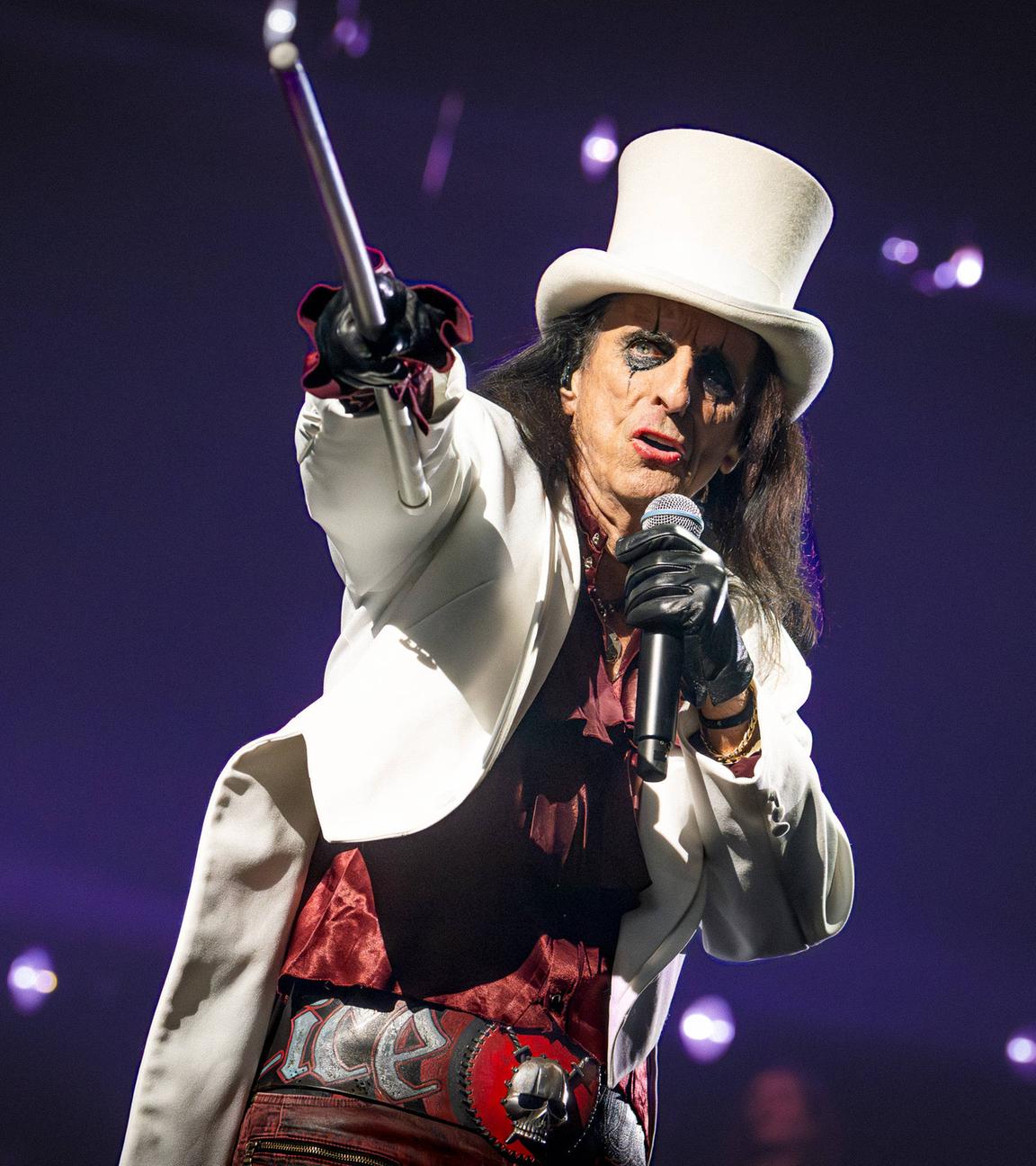 Alice Cooper in weißer Jacke und weißen Hut gekleidet mit Spazierstock in der Hand singt bei seinem Auftritt für "Die Night of the Proms" in der Festhalle Frankfurt