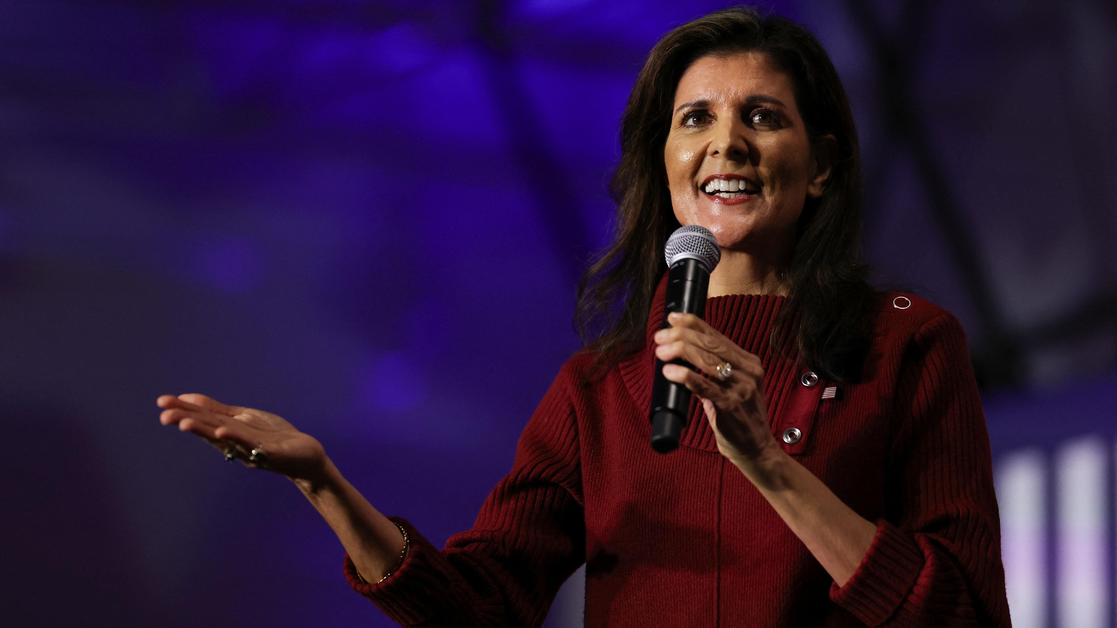 Die republikanische Präsidentschaftskandidatin Nikki Haley spricht in rotem Oberteil  und auslandender Handbewegung während eines Wahlkampfbesuchs vor den republikanischen Präsidentschaftswahlen in South Carolina.