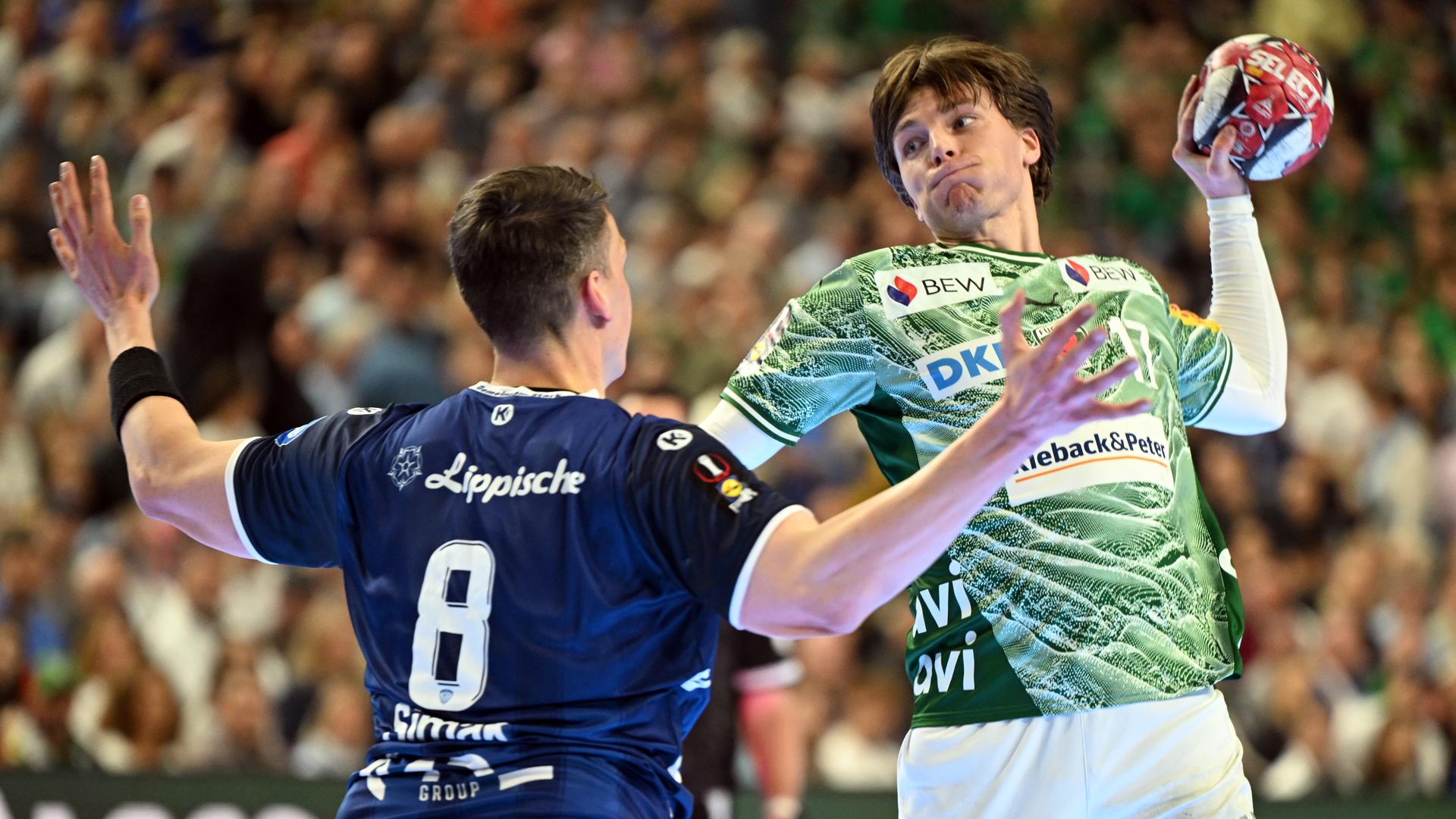 Frederik Simak (TBV Lemgo) und Nils Lichtlein (Füchse Berlin) kämpfen am 18.04.2026 in der Lanxess Arena in Köln um den Ball.