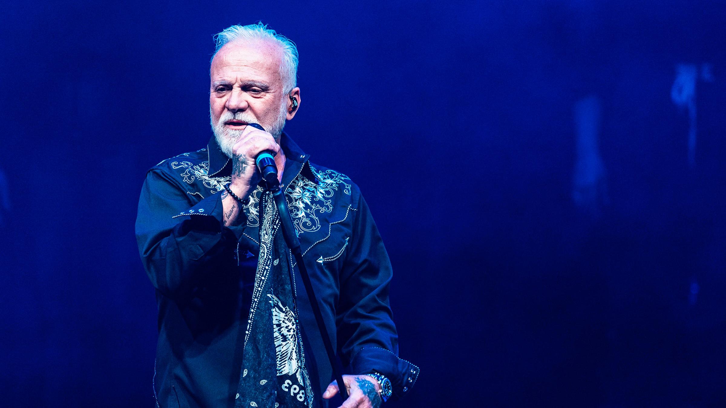 Der Sänger Nino de Angelo steht auf einer Bühne und singt