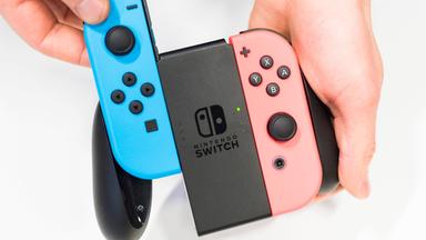 Symbolbild: Ein mann hält einen Controller der Spielkonsole Nintendo Switch in der Hand