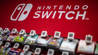 Hinter einer Auswahl an Nintendo-Spielen prangt in weißer Schrift auf rotem Grund der Schriftzug "Nintendo Switch".