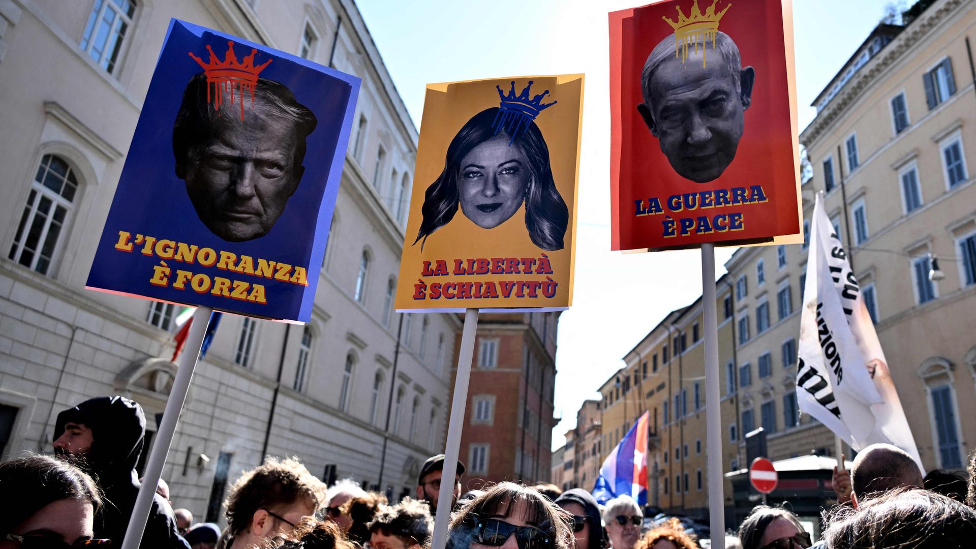 Proteste in Rom am 28. März 2026: Demonstrierende halten Schilder mit Abbildungen von US-Präsident Trump (l.), Italiens Ministerpräsidentin Meloni (M.) und dem israelischen Regierungschef Netanjahu (r) .