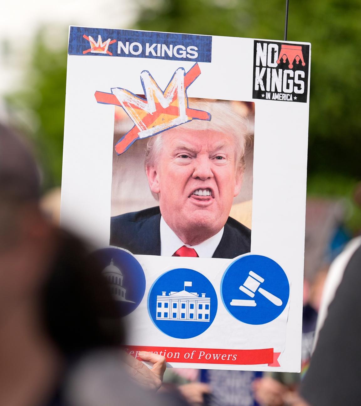 14.06.2025, USA, Atlanta: Ein Demonstrant hält ein Schild mit einem Foto des US-Präsidenten Trump, der eine hässliche Fratze zieht, während einer "No Kings"-Demonstration am Samstag, 14. Juni 2025, in Atlanta, Georgia.
