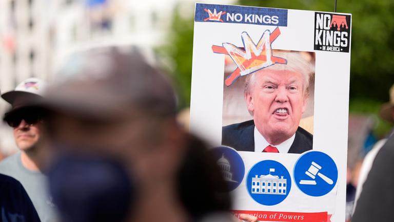 14.06.2025, USA, Atlanta: Ein Demonstrant hält ein Schild mit einem Foto des US-Präsidenten Trump, der eine hässliche Fratze zieht, während einer "No Kings"-Demonstration am Samstag, 14. Juni 2025, in Atlanta, Georgia.