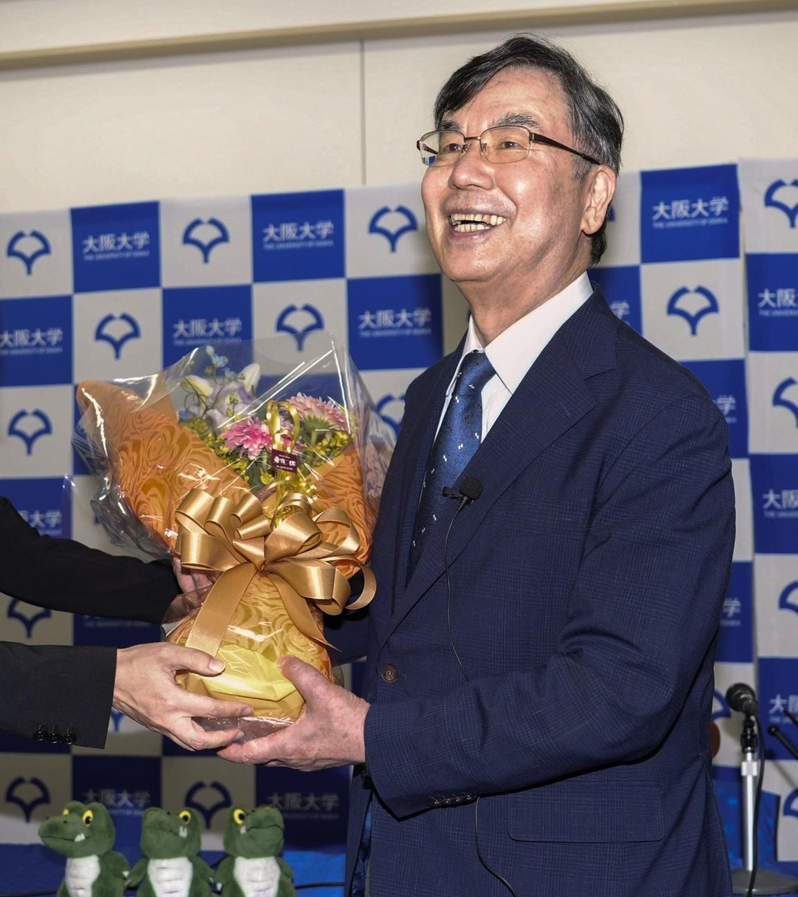 Shimon Sakaguchi (r), Professor an der Universität Osaka, erhält bei einer Pressekonferenz in Suita Blumen, nachdem er den Nobelpreis für Medizin erhalten hat. 