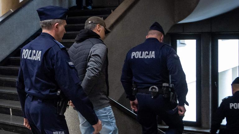 Polizeibeamte eskortieren den ukrainischen Angeklagten Volodymyr Zhuravlyov aus dem Gericht in Warschau nach einer Anhörung wegen mutmaßlicher Sabotage an der Nord-Stream-2-Pipeline.