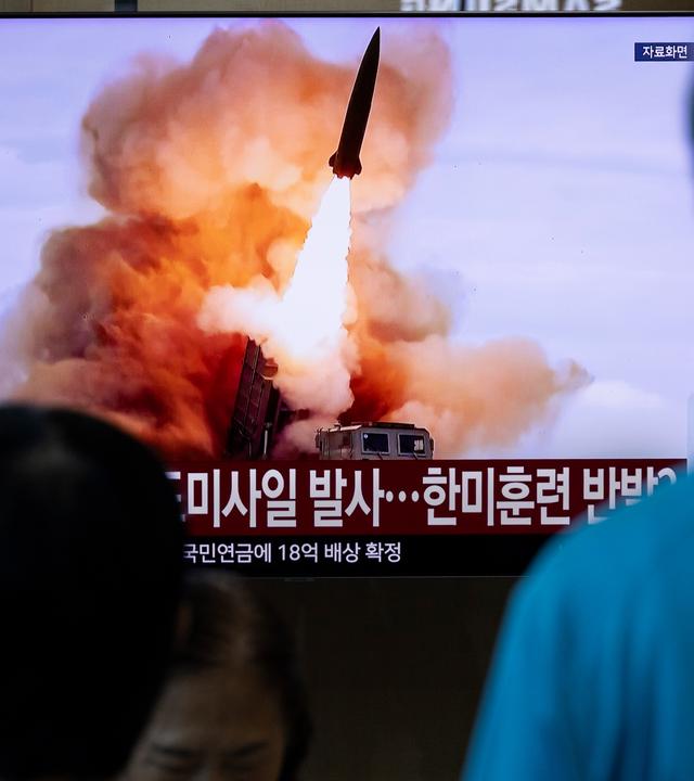Menschen verfolgen an einem Bahnhof in Seoul (Südkorea) am 12.08.2026 eine Nachrichtensendung über den Start einer Rakete