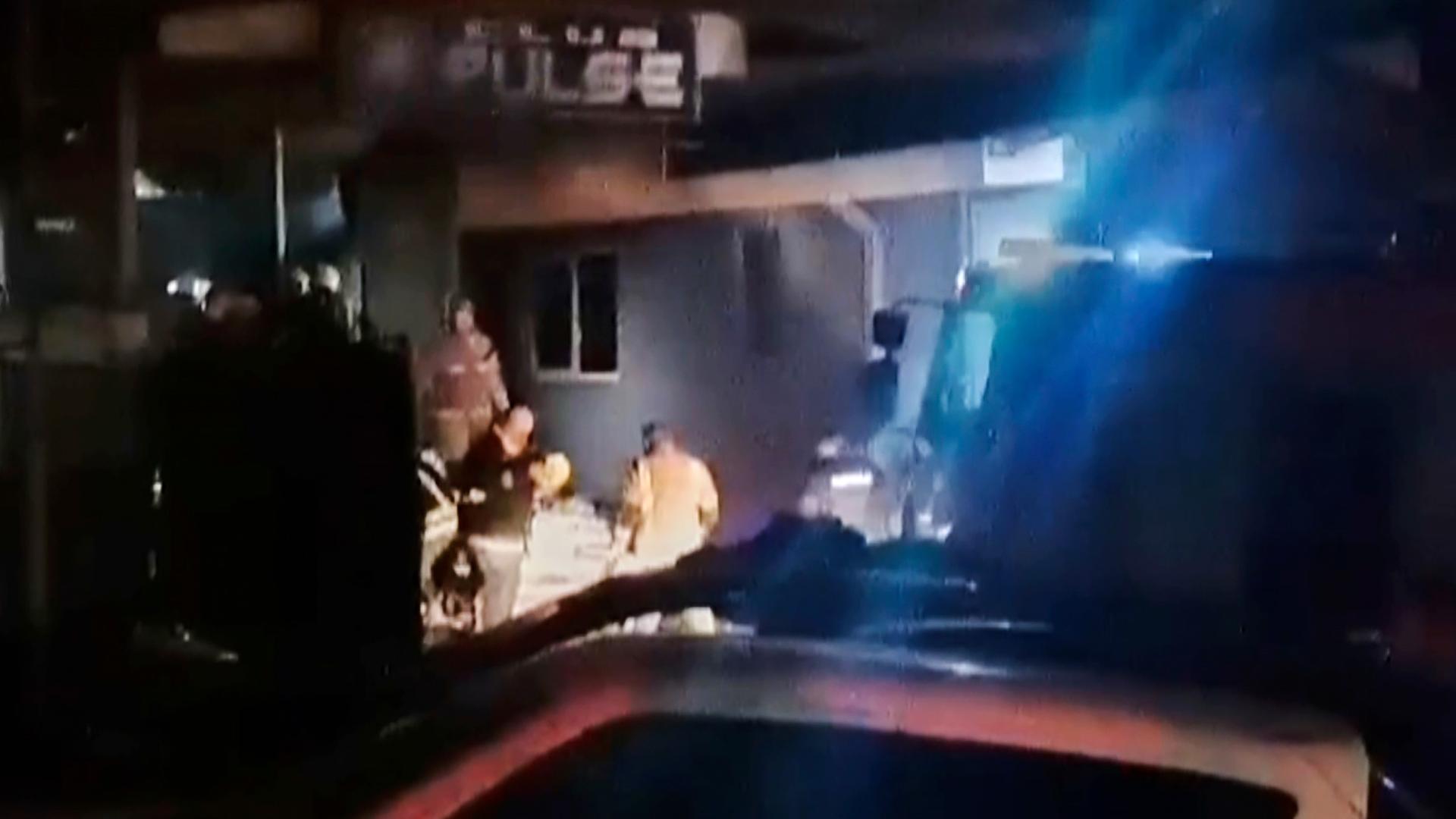 Rettungskräfte stehen vor einem Club in Kocani (Nordmazedonien), nachdem am 16.03.2025 ein Großbrand ausgebrochen ist