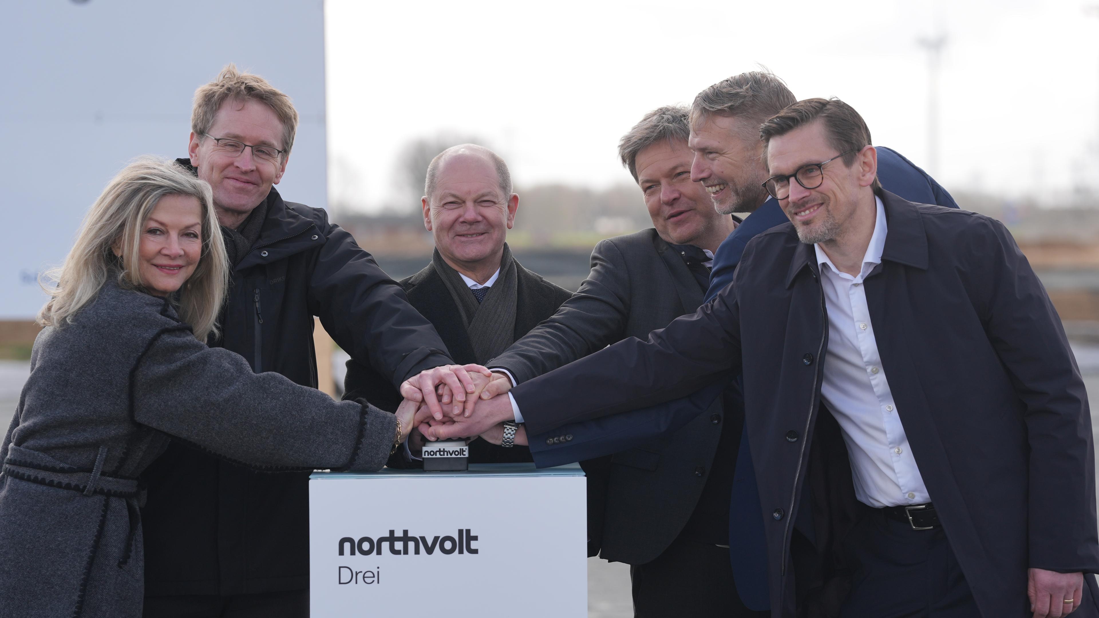 Veronika Wand-Danielsson (l-r), Schwedische Botschafterin in Deutschland, Daniel Günther (CDU), Ministerpräsident von Schleswig-Holstein, Bundeskanzler Olaf Scholz (SPD), Robert Habeck (Bündnis 90/Die Grünen), Vizekanzler und Bundesminister fu·r Wirtschaft und Klimaschutz, Peter Carlsson, CEO von Northvolt, und Christofer Haux, Northvolt-Geschäftsführer, drücken gemeinsam den roten Knopf für den Start des Baus. Bundeskanzler Scholz und Wirtschaftsminister Habeck nehmen am offizieller Baubeginn der Northvolt-Fabrik teil, in der ab 2026 Batteriezellen für Elektroautos produziert werden sollen