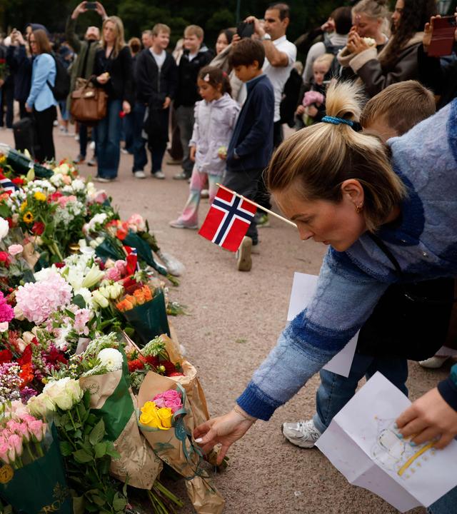 Menschen legen in Gedenken an den verstorbenen norwegischen König Harald V. Blumen nieder.