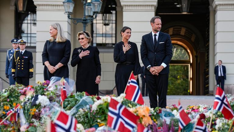 Königin Mette-Marit, Königin Sonja, Prinzessin Märtha Louise und König Haakon schauen auf Blumen auf dem Schlossplatz in Oslo. 