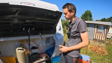 Björn Henneke an einem Caravan, gerade dabei etwas zu reparieren 