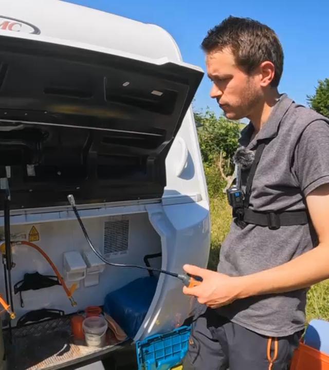 Björn Henneke an einem Caravan, gerade dabei etwas zu reparieren 