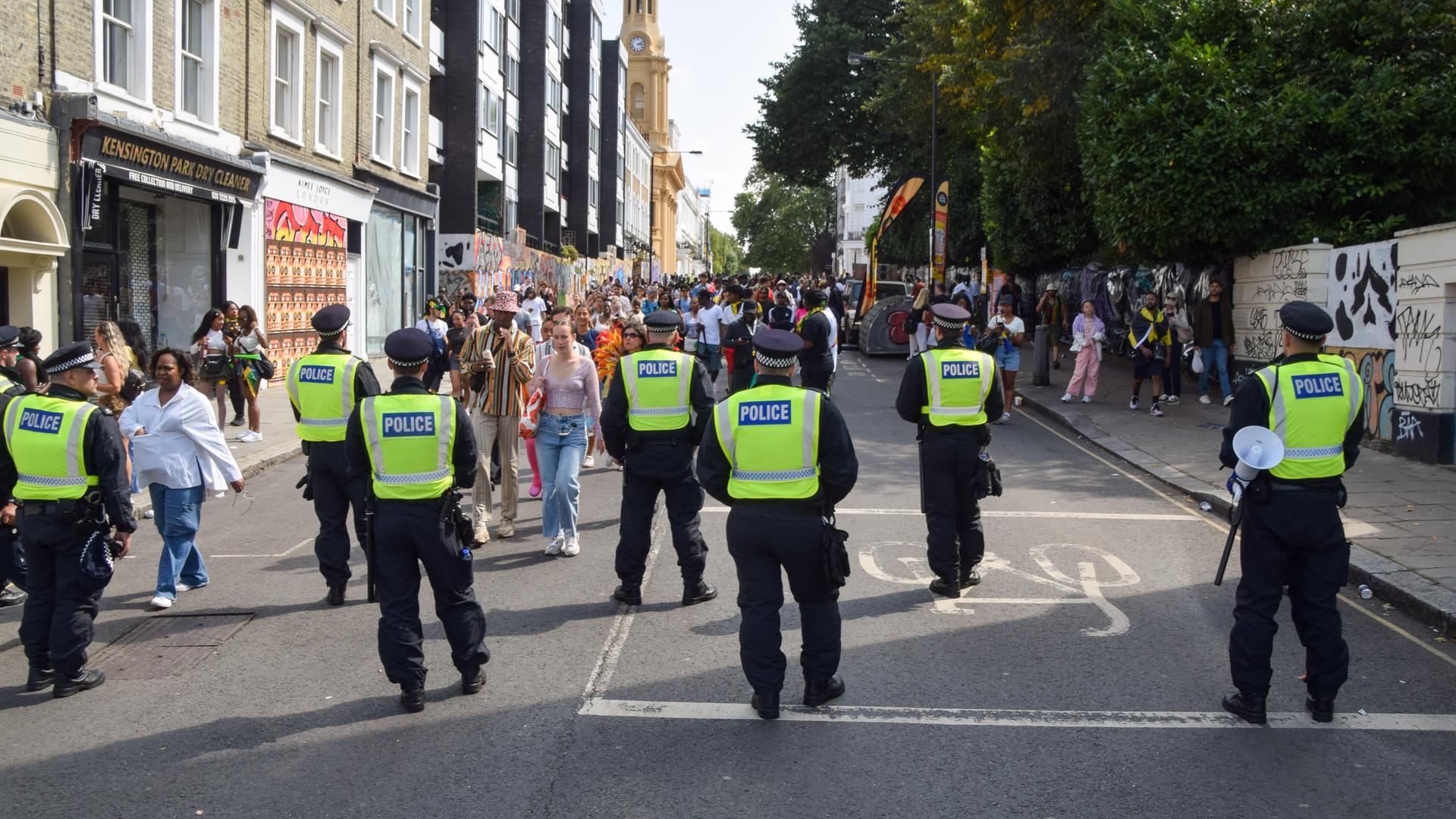 ARCHIV - 26.08.2024, Großbritannien, London: Polizeibeamte beobachten die Menschenmenge am zweiten Tag des Notting Hill Carnival. Die jährliche Veranstaltung in Londons beliebtem Stadtteil Notting Hill zieht rund eine Million Menschen an und ist vor allem ein Fest der karibischen Kultur.