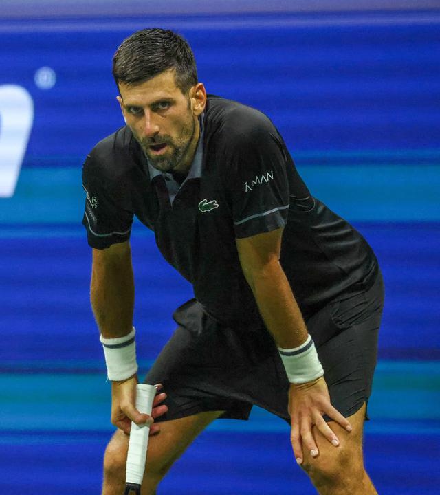 Tennisspieler Novak Djokovic stützt seine Hände auf seine Knie am 30.08.2026 im USTA Billie Jean King National Tennis Center in Flushing, New York, in einem Erstrundenspiel der US Open 2026 gegen Mariano Navone. 