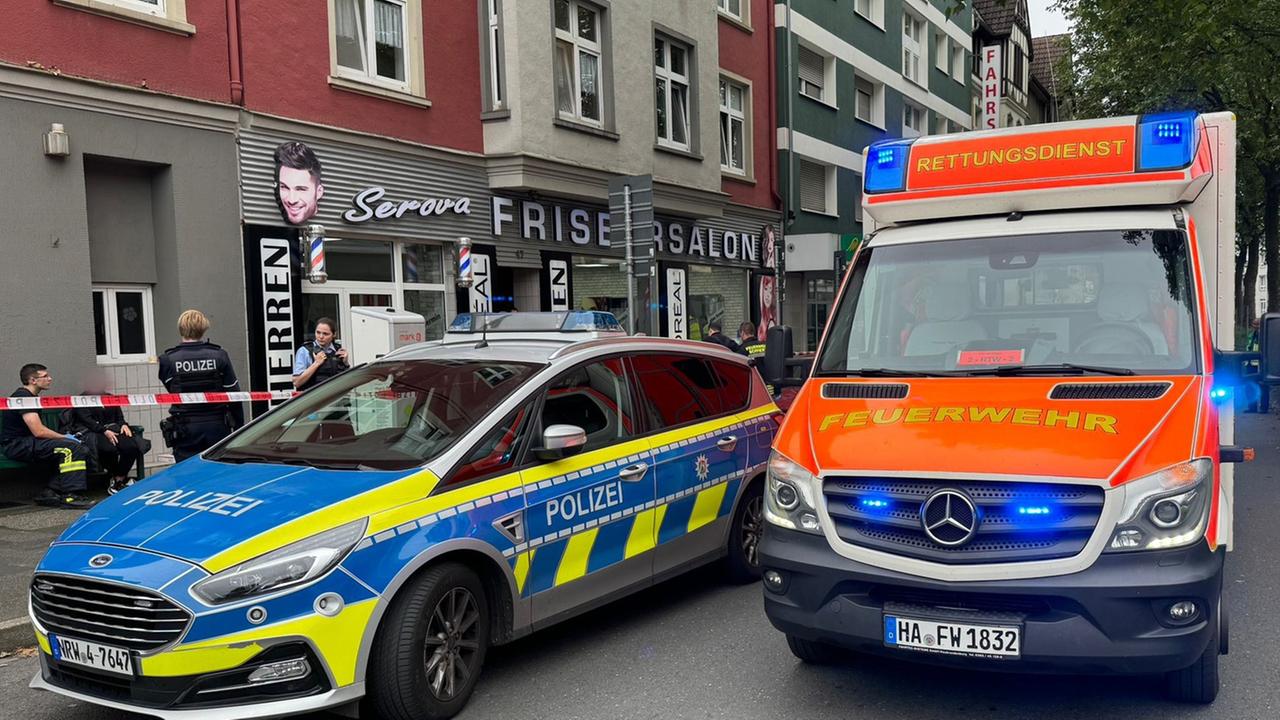 Nordrhein-Westfalen, Hagen: Ein Einsatzfahrzeug der Polizei und ein Rettungswagen der Feuerwehr stehen vor einem Friseursalon.