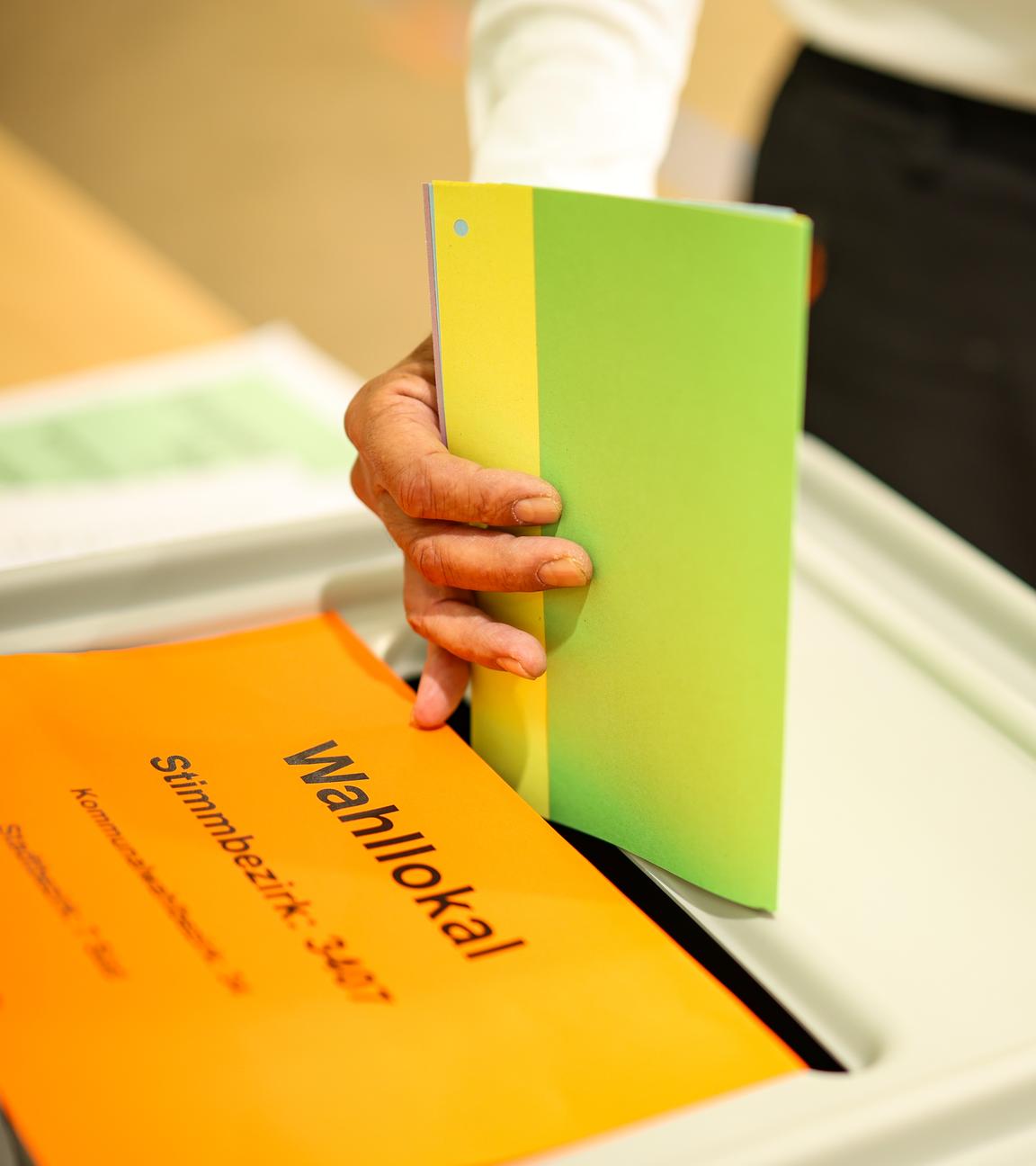 Wahlzettel wird in die Urne geworfen