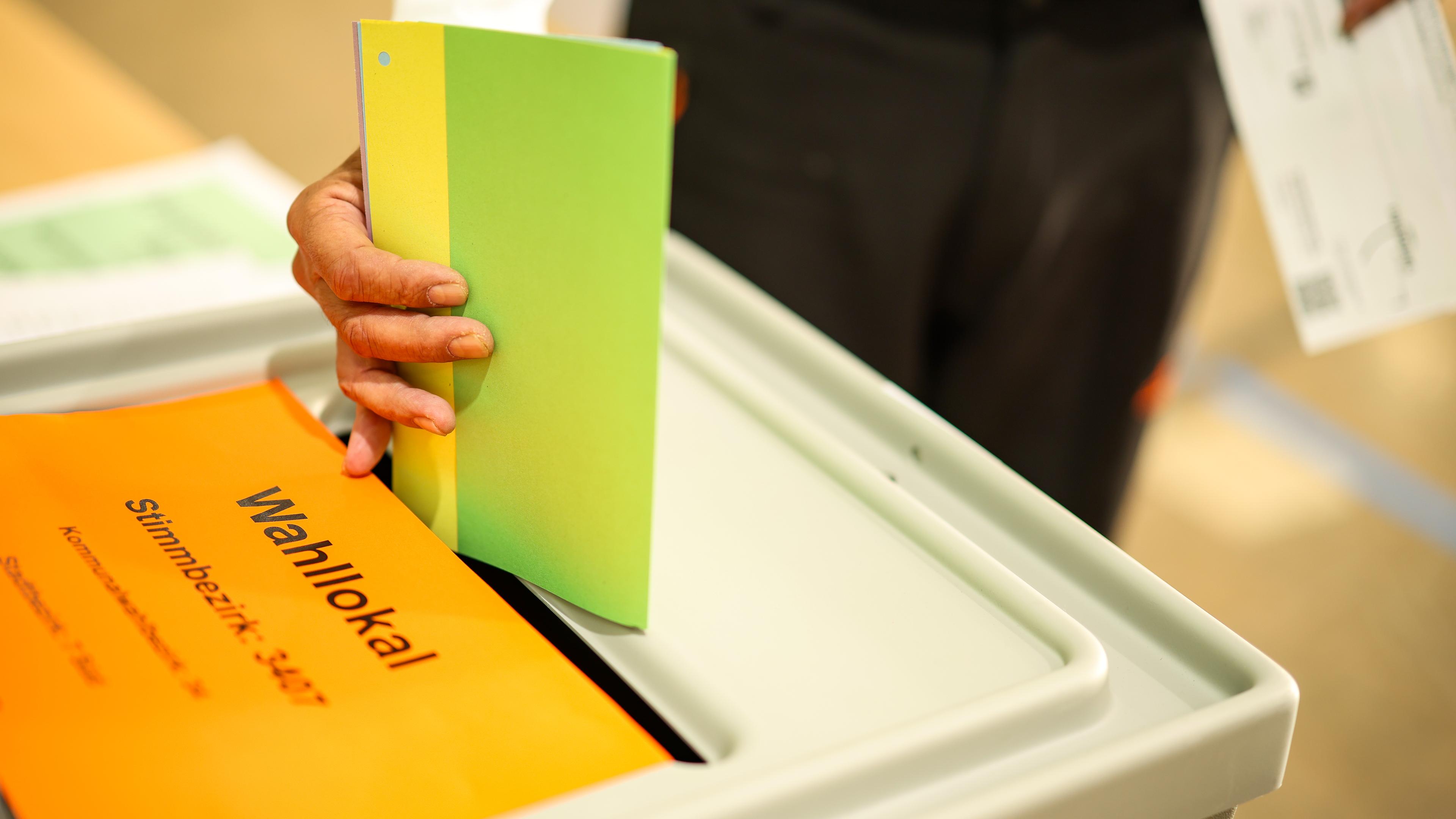 Wahlzettel wird in die Urne geworfen