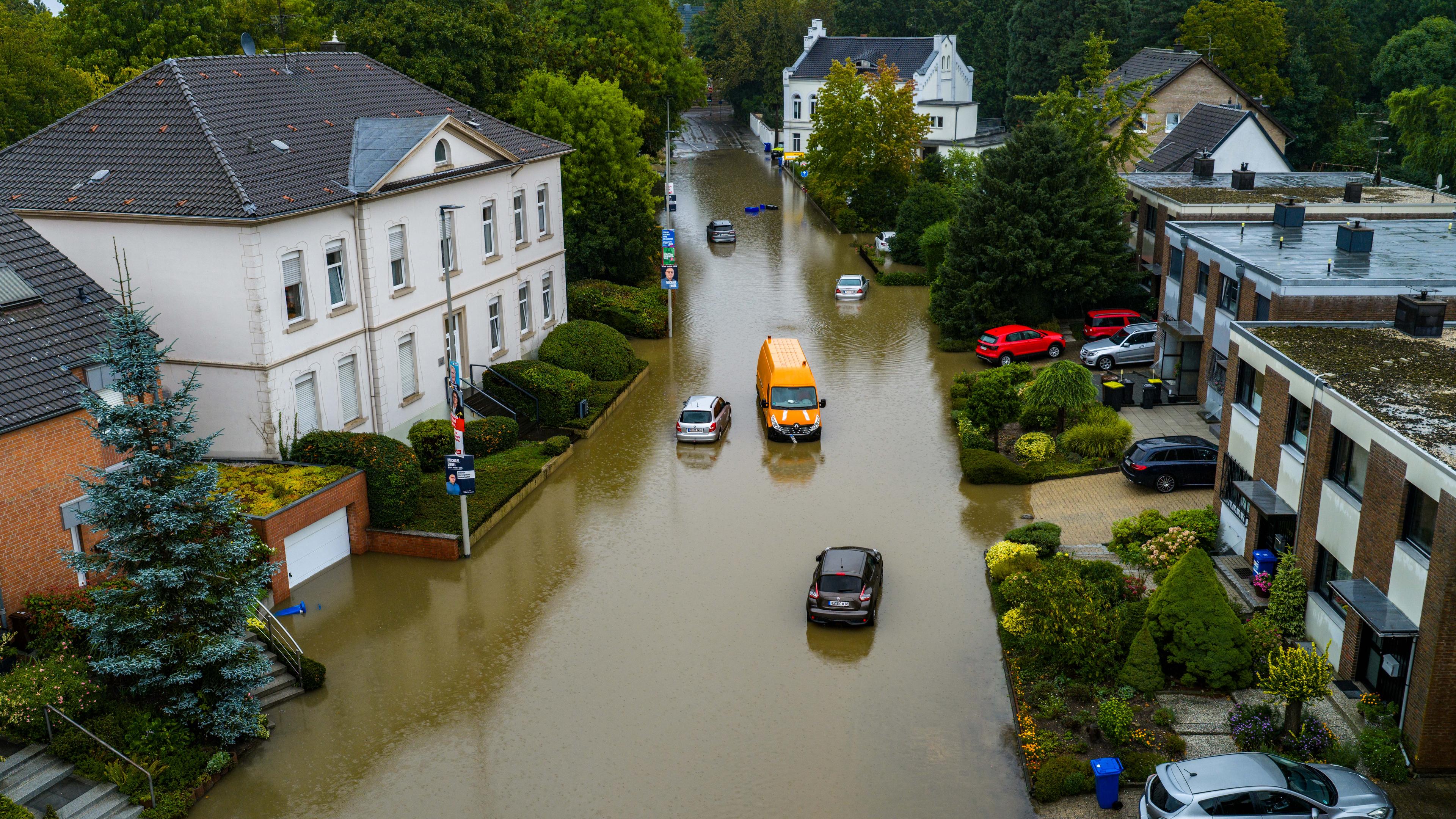 ordrhein-Westfalen, Mönchengladbach: Autos stehen in den Wassermassen in einer überschwemmten Straße in Mönchengladbach-Rheydt (Luftbild mit einer Drohne)