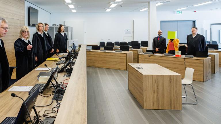 Simone Herberger (2ndL), presiding judge at the Higher Regional Court, stands in the courtroom prior to the start of the trial of Susann E. (2ndR) as suspected supporter of the far-right extremist cell National Socialist Underground (NSU),