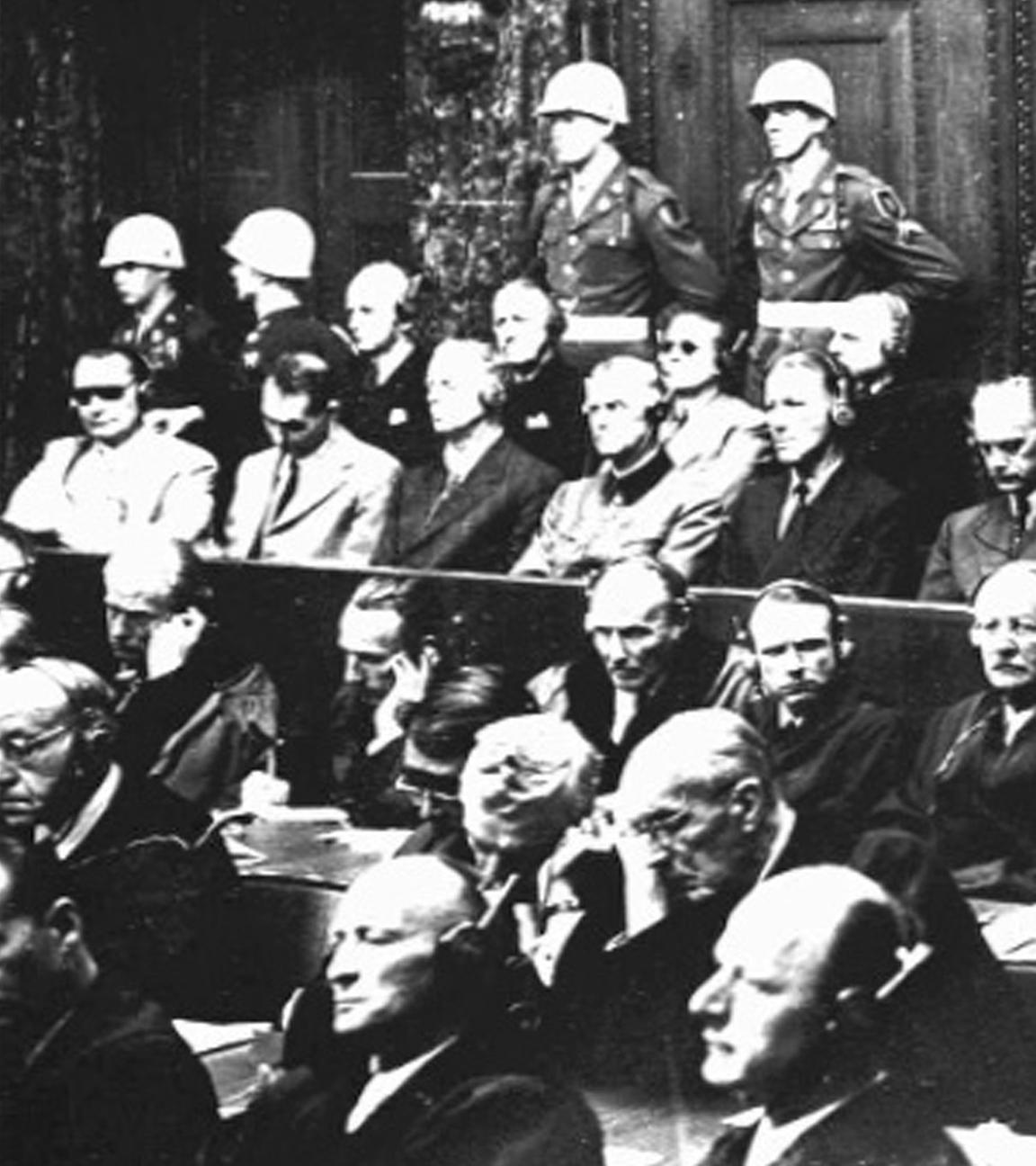 Archivaufnahme vom 30. September 1946: Alle 21 Angeklagten der Nürnberger Kriegsverbrecherprozesse, darunter in der ersten Reihe (v.l.) Hermann Göring, Rudolf Heß, Joachim von Ribbentrop, Wilhelm Keitel, Ernst Kaltenbrunner, Alfred Rosenberg, Hans Frank, Wilhelm Frick, Julius Streicher und Walter Funk; in der zweiten Reihe (v.l.) Karl Dönitz, Erich Raeder, Baldur von Schirach, Fritz Sauckel, Alfred Jodl, Franz von Papen, Arthur Seyß-Inquart und Albert Speer.