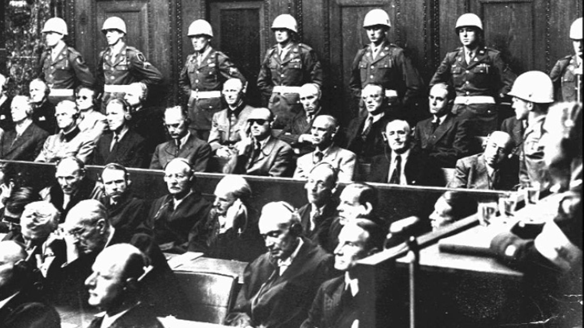 Archivaufnahme vom 30. September 1946: Alle 21 Angeklagten der Nürnberger Kriegsverbrecherprozesse, darunter in der ersten Reihe (v.l.) Hermann Göring, Rudolf Heß, Joachim von Ribbentrop, Wilhelm Keitel, Ernst Kaltenbrunner, Alfred Rosenberg, Hans Frank, Wilhelm Frick, Julius Streicher und Walter Funk; in der zweiten Reihe (v.l.) Karl Dönitz, Erich Raeder, Baldur von Schirach, Fritz Sauckel, Alfred Jodl, Franz von Papen, Arthur Seyß-Inquart und Albert Speer.