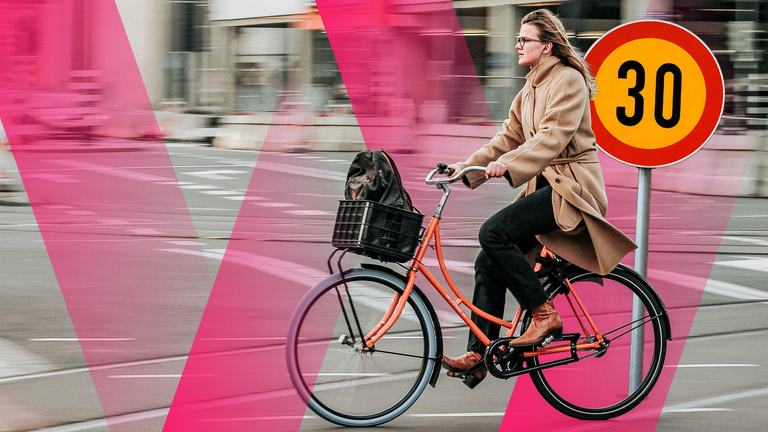 Frau radelt in der Stadt Helsinki, gelbes Nummernschild mit Tempo 30