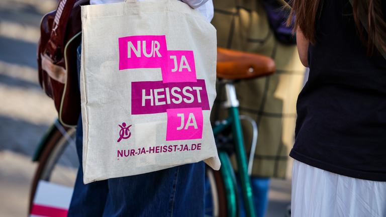 Nordrhein-Westfalen, Köln: Bei einer Demo anlässlich des Internationalen Frauentages trägt eine Teilnehmerin eine Stofftasche mit der Aufschrift "Nur ja heisst ja".