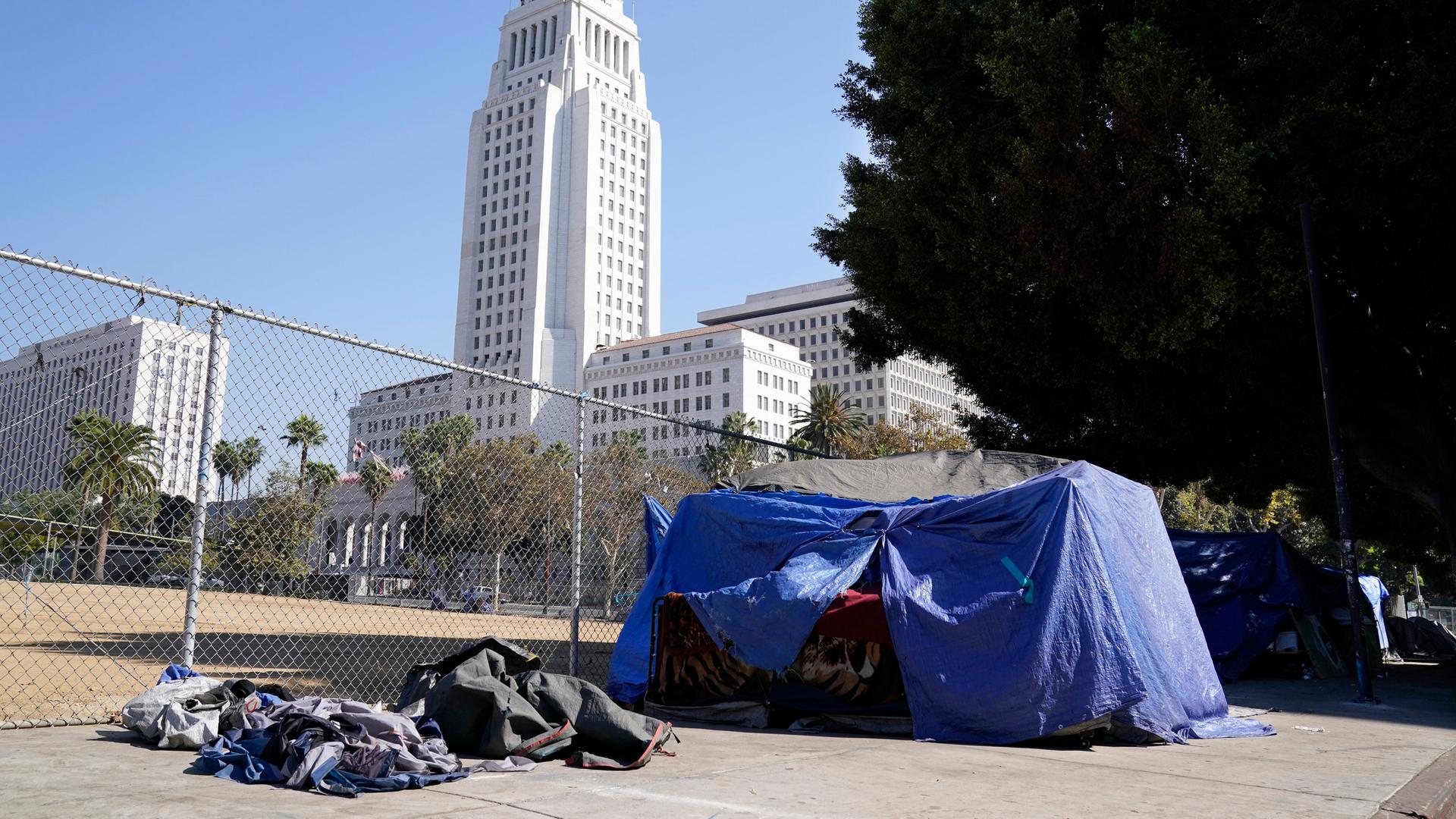 Archiv: Das Zelt eines Obdachlosen steht direkt vor dem Grand Park mit dem Rathaus von Los Angeles im Hintergrund, Mittwoch, 28. Oktober 2020, in Los Angeles.