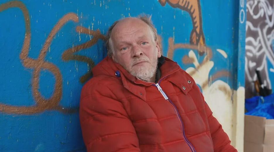 Ein Obdachloser in roter Winterjacke.
