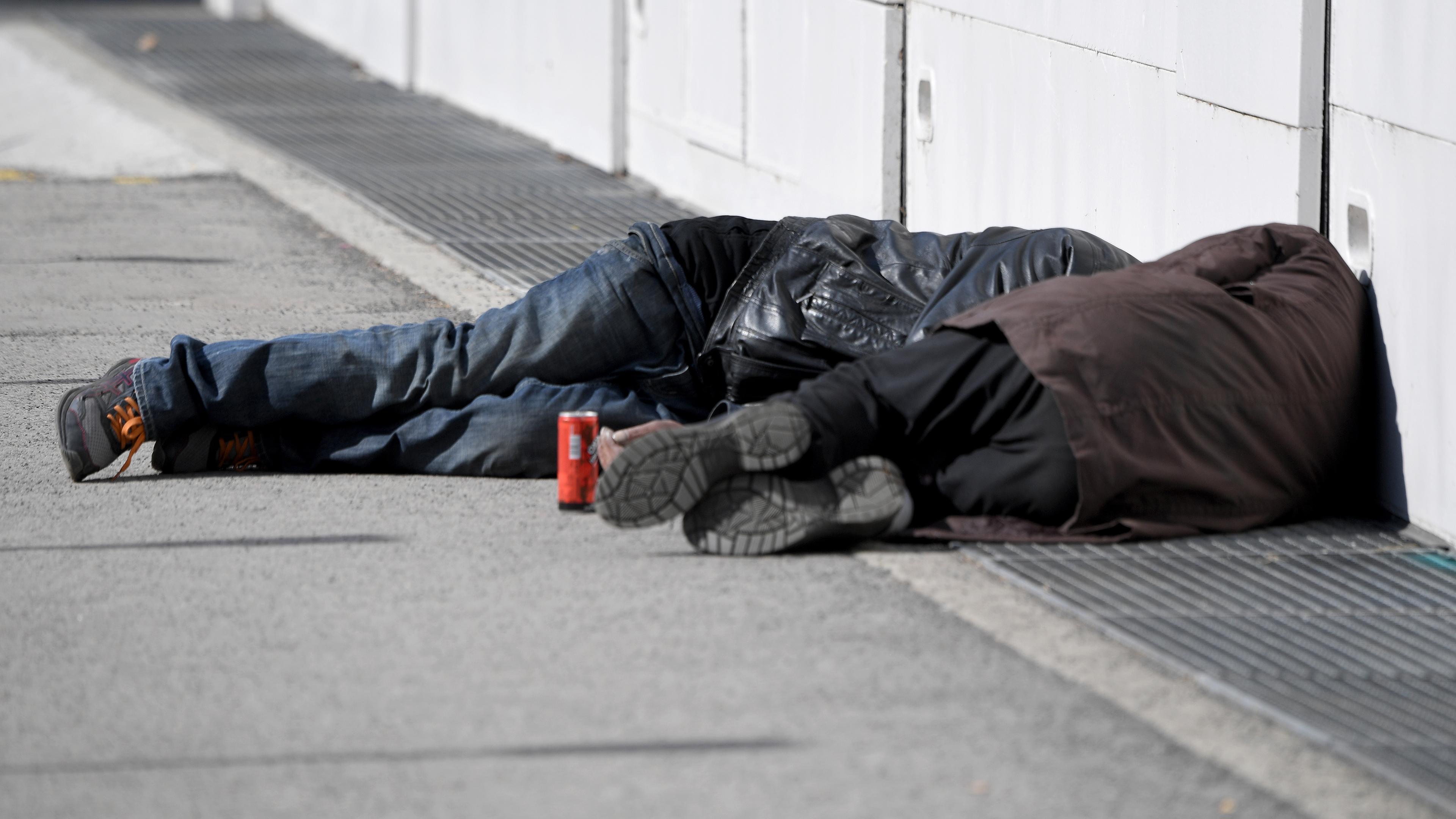 Zwei Obdachlose Männer schlafen auf der Straße.