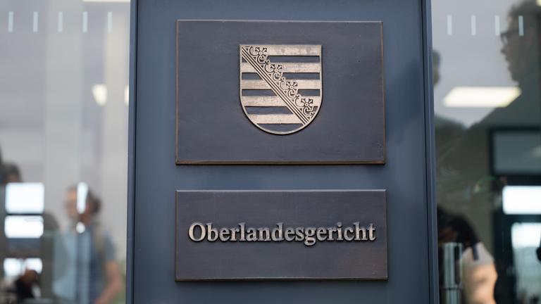 Der Schriftzug "Oberlandesgericht" ist an einer Stehle vor dem Prozessgebäude in Dresden zu lesen.