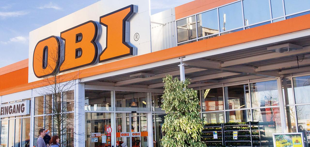 Pflanzen und Gartenzubehör stehen am Haupteingang eines Baummarkts von Obi.