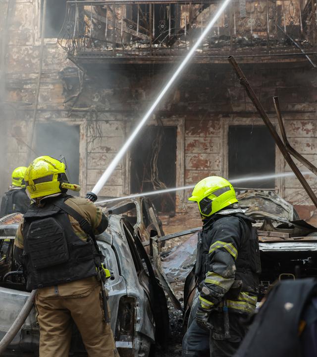 Ukrainische Rettungskräfte bei Löscharbeiten nach einem Raketeneinschlag. 