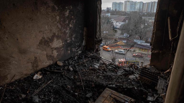Ein zerstörtes Zimmer ohne Fenster, mit Blick auf Einsatzfahrzeuge auf der untenliegenden Straße, in Odessa, Ukraine, am 31.12.2025.