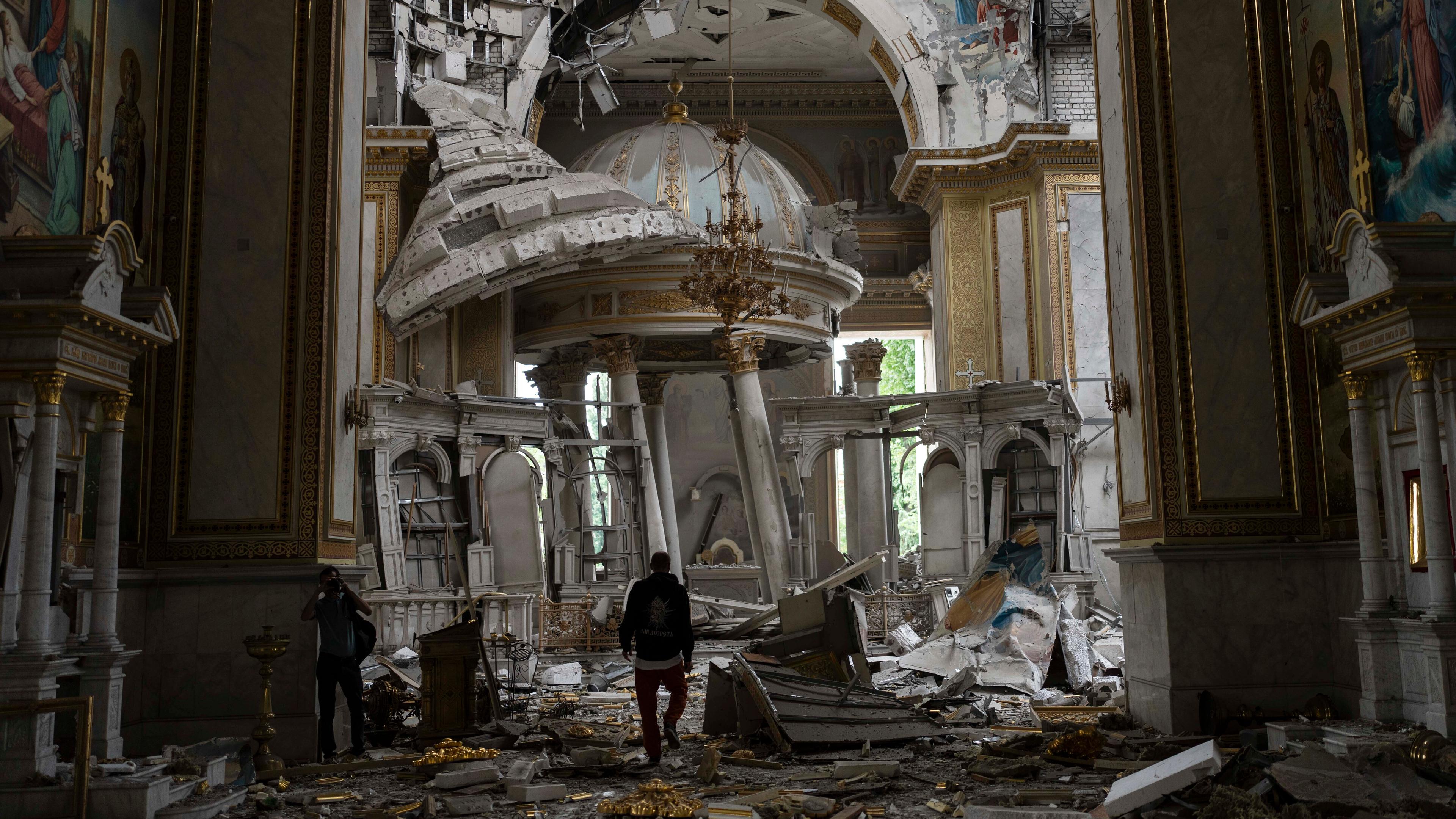 Kirchenmitarbeiter inspizieren die Schäden in der Verklärungskathedrale nach Raketenangriffen.