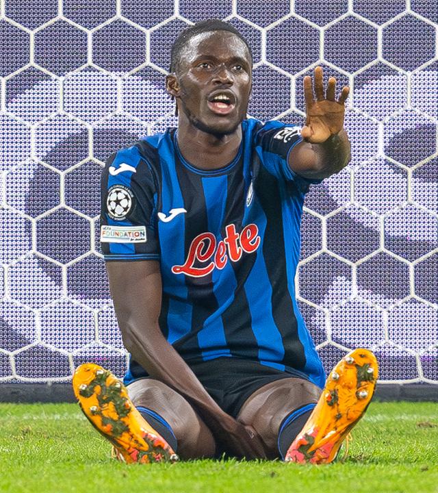 Bergamos Fußballer Odilon Kossounou sitzt auf dem Spielfeld am 02.10.2024 in Gelsenkirchen während der Champions League.