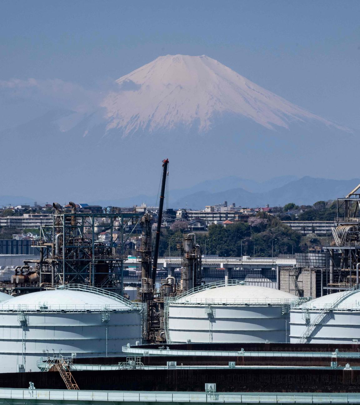 Lagertanks einer Ölraffinerie sind zu sehen, während sich der Berg Fuji im Hintergrund bei Yokohama in der Präfektur Kanagawa erhebt.