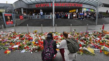 Blumen und Kerzen liegen vor dem Haupteingang des Olympia-Einkaufszentrums (OEZ).