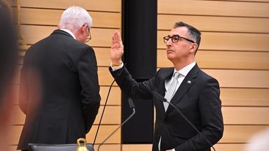 Cem Özdemir hebt die Hand bei der Vereidigung als Ministerpräsident von Baden-Württemberg.