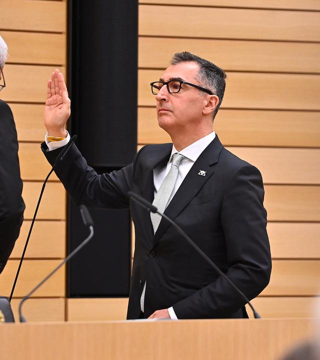 Cem Özdemir hebt die Hand bei der Vereidigung als Ministerpräsident von Baden-Württemberg.