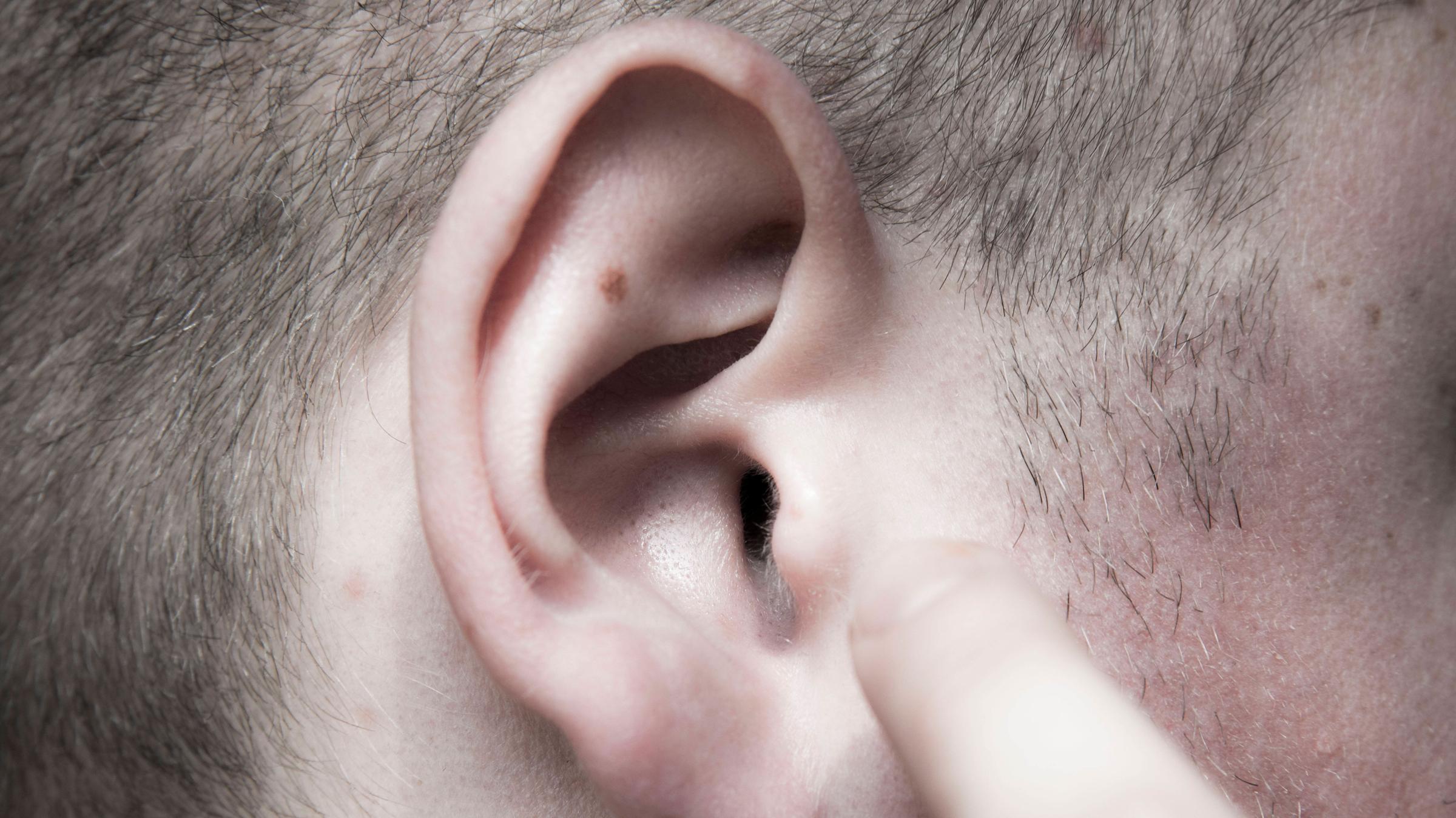 Das rechte Ohr eines Mannes in Nahaufnahme.