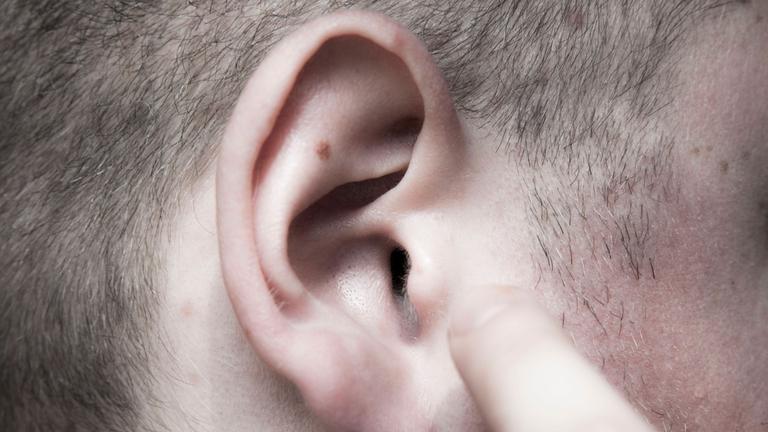 Das rechte Ohr eines Mannes in Nahaufnahme.