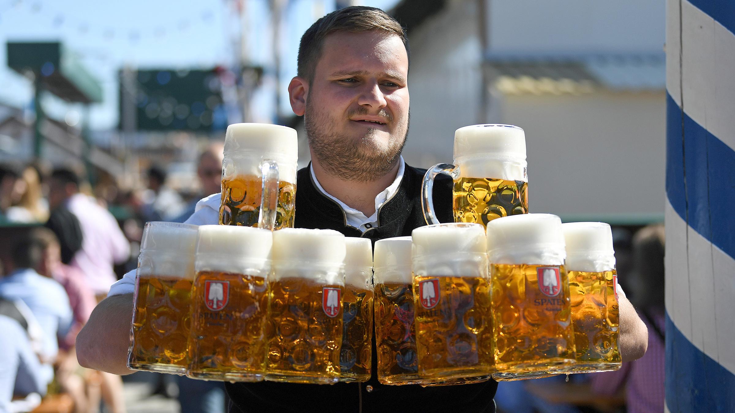 Bedienung trägt Krüge am Eröffnungstag der Wiesn