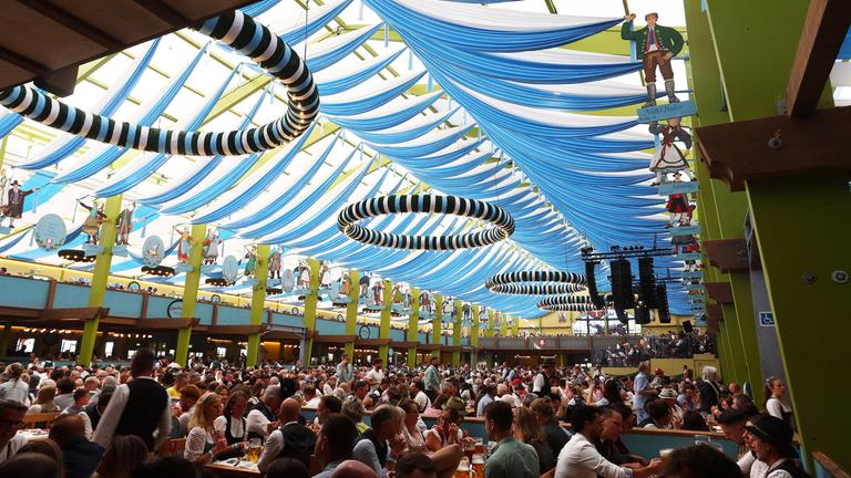 Im Innenraum eines Fetszeltes auf dem Münchner Oktoberfest 2026 sitzen viele Menschen.