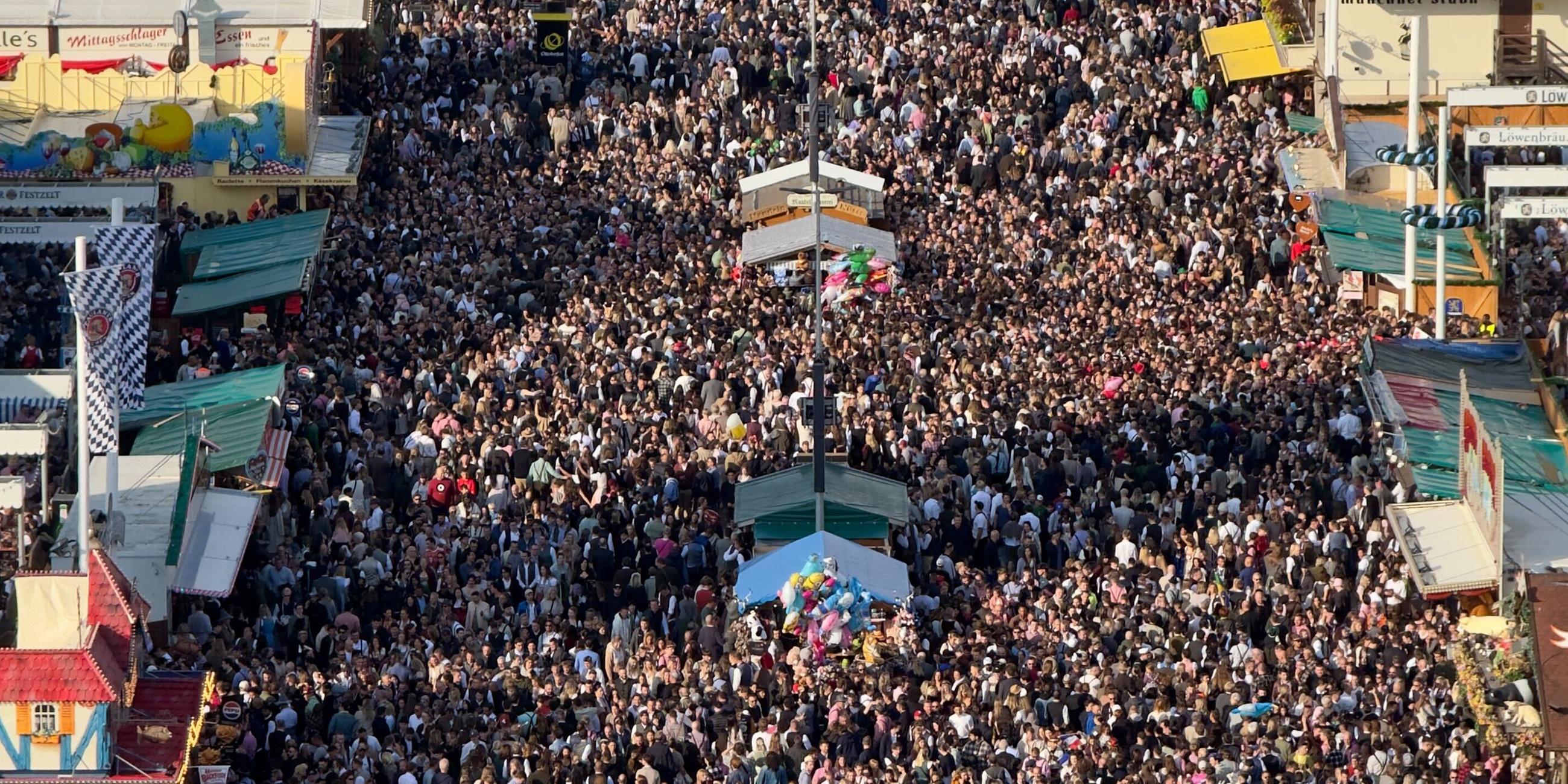 27.09.2025, Bayern, München: Blick vom Riesenrad auf die Besucher der 190. Wiesn.